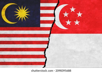 Singapore and Malaysia painted flags on a wall with a crack. Singapore and Malaysia conflict. Malaysia and Singapore flags together. Singapore vs Malaysia