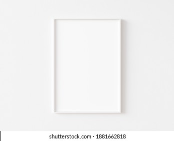 Single blank vertically oriented rectangular picture frame with thin white border hanging on white wall. 3D illustration.