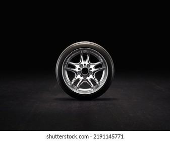 Single Car Tire On A Garage Floor Rubber Wheel With Shiny Chrome Rim. 3d Rendering, Nobody, Front View