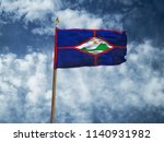 Sint Eustatius flag Silk waving flag of Sint Eustatius island made transparent fabric with wooden flagpole gold spear background blue sky white smoke clouds real photo Countries world 3d illustration