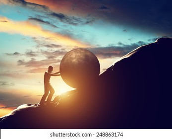 Sisyphus metaphor. Man rolling huge concrete ball up hill. Sisyphean work, task. 