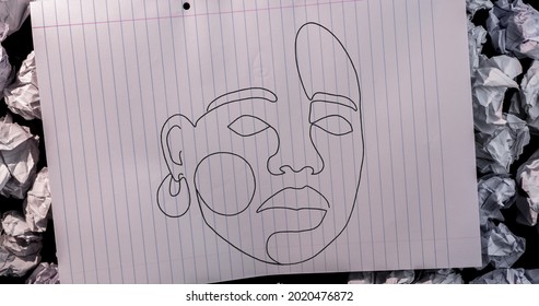 Sketch Of Woman Face On White Lined Paper Against Crumbled Papers In Background. School And Education Concept