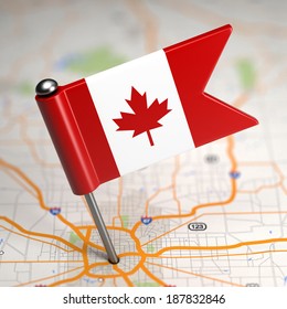 Small Flag of Canada on a Map Background with Selective Focus.