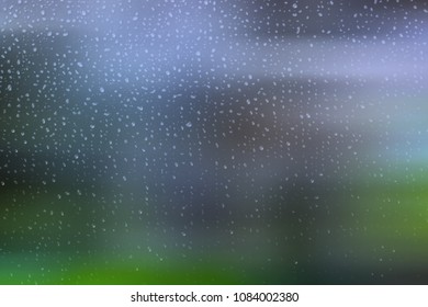 Small raindrops on a window with a green and blue blurred background. Abstract illustration