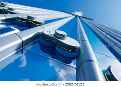 Smart window cleaning robots working on a big building reflective windows. Automatic cleaning devices keep the glass clean. Remote control window washing in the futuristic city.