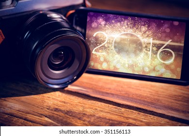 Smartphone And Camera Against New Year Countdown Graphic