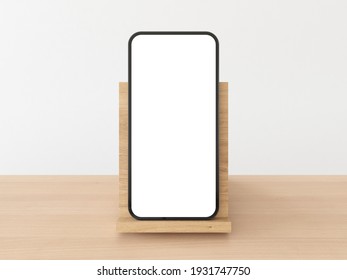 Smartphone frame with blank white display standing upright on wooden stand on natural wooden table with white background. Realistic smartphone mockup. 3D illustration
