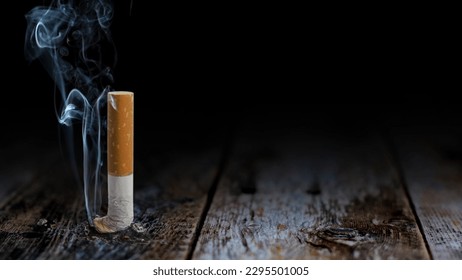 Smoke of Death Table Butt Background features a cigarette crushed out on a rustic wooden table top with smoke rising from the tip of the cigarette.
