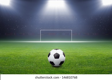 Soccer Ball On Green Stadium, Arena In Night Illuminated Bright Spotlights, Soccer Goal