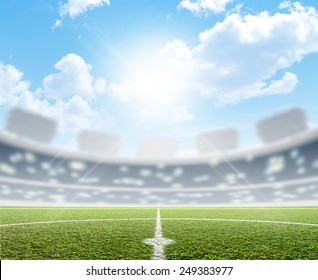 A Soccer Stadium With A Marked Green Grass Pitch In The Daytime Under A Blue Sky