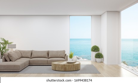 Sofa On Wooden Floor Of Large Living Room In Modern House Or Luxury Hotel. Minimal Home Interior 3d Rendering With Sky And Sea View.