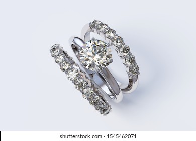 Solitaire Diamond Engagement Ring, Two Eternity Rings On White Background. 3D Illustration