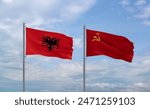 Soviet Union or USSR and Albania flags waving together in the wind on blue cloudy sky, two country relationship concept