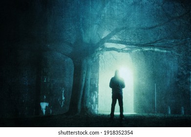 A spooky hooded figure. Standing under an arch in city street on a foggy winters night. With a grunge, artistic, edit