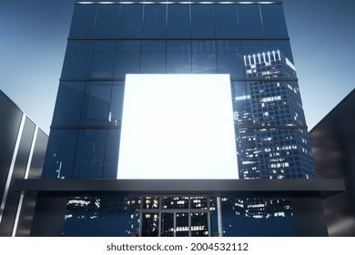 Square White Billboard On Shiny Glass Building Exterior With Reflections At Night Time. Mock Up, 3D Rendering