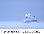 Stack of books with headphones isolated on pastel blue background. Audiobook concept. Minimal style. 3d rendering
