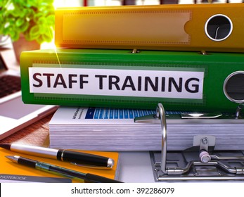 Staff Training - Green Office Folder on Background of Working Table with Stationery and Laptop. Staff Training Business Concept on Blurred Background. Staff Training Toned Image. 3D. - Powered by Shutterstock