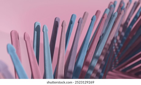 Standing upright on a soft pink background, pastel pink and blue crochet hooks create a whimsical scene, casting shadows in a 3d render perfect for craft enthusiasts - Powered by Shutterstock