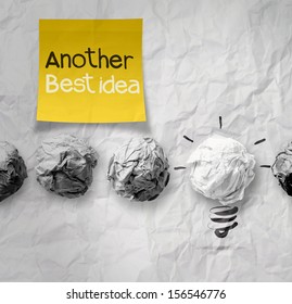 sticky note with another idea light bulb on crumpled paper as creative concept