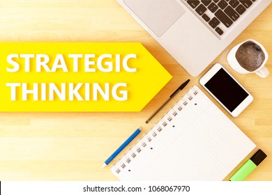 Strategic Thinking - linear text arrow concept with notebook, smartphone, pens and coffee mug on desktop - 3D render illustration.