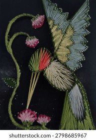 String art work of a Java sparrow perched on a flower taking some honey 