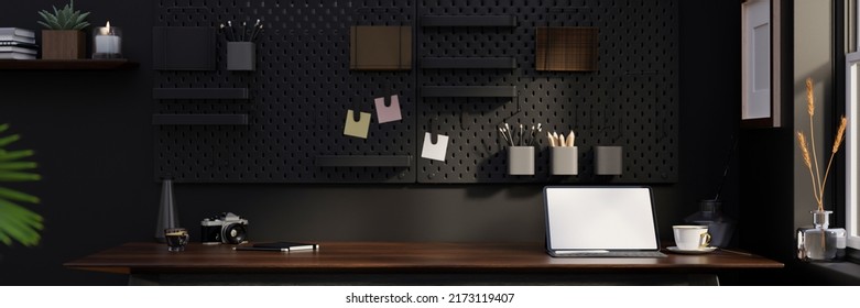 Stylish Black Home Workspace Interior Design With Portable Tablet Touchpad White Screen Mockup, Accessories And Copy Space On Wood Table, Black Pegboard On Black Wall. 3d Rendering, 3d Illustration