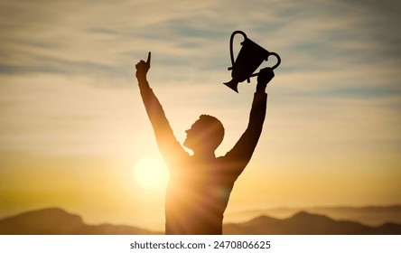 Success, achieving goals in business and life, feeling of triumph. Holding trophy in hand, symbol of achievement. silhouette of man hand with trophy at sunset, joy and satisfaction with success - Powered by Shutterstock