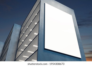 Sunny blank white billboard on dark wall of modern skyscraper on sunset. 3D rendering, mock up