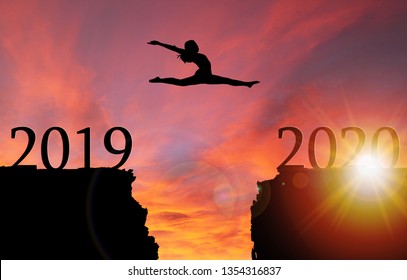 Sunrise silhouette of girl leaping from 2019 toward 2020 over cliff. Concept of boldness, courage, or leap of faith toward a new year.