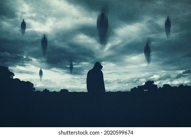 A Supernatural Concept. Of Spirits Floating Above A Hooded Figure In The Countryside At Night. With A Grunge, Textured Edit.