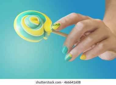 Sweet green yellow candy in her hands and manicure blue gradient background  Green yellow nail art 