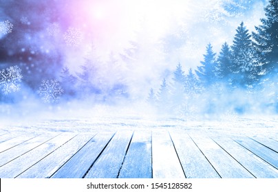 The table is wooden and there is free space for your text or product decoration. Landscape in the winter. Blurred branches of spruce and frost, bokeh.