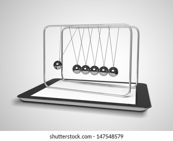 tablet and newton's cradle on a gray background