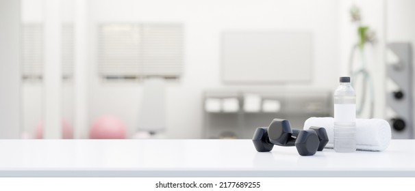 Tabletop With Dumbbells, Water Bottle, Towel And Copy Space For Montage Your Product Display Over Blurred Modern Bathroom Background. Sport And Gym Background Concept. 3d Rendering, 3d Illustration