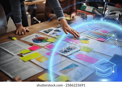 Team planning with colorful charts, sticky notes, and digital graphics. Hands pointing at documents. Creative brainstorming session with diverse team members. Business image.
