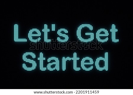 The text "Let's Get Started" is illuminated with blue LED. Motivation, beginnings and teamwork concept. 3D illustration