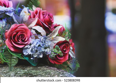 Textured artistic composition, Silk flowers on a gravestone, soft focus                                - Powered by Shutterstock