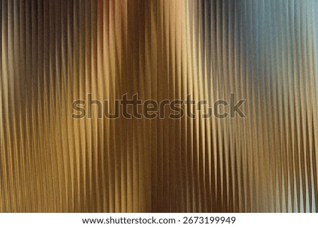 A textured background with vertical ribbed lines, featuring a gradient of warm golden brown to cool blue tones, creating a sense of depth and abstract beauty