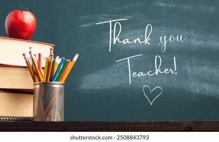 Thank you Teacher written on blackboard with chalk on Happy Teacher's Day, side pencils and books placed on table, a heart sign on blackboard - Powered by Shutterstock