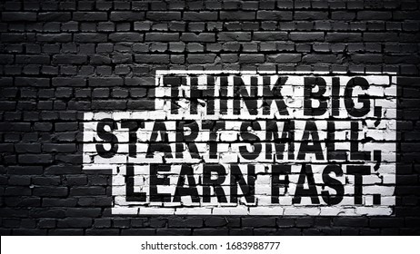 Think big, start small, learn fast, motivation and inspiration slogan, white text on black brick wall - Powered by Shutterstock