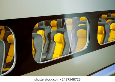This image captures an artistic view of the interior of a bus, showcasing a repetitive design of yellow seats viewed through windows, emphasizing patterns and geometry.