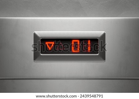 This image captures a detailed view of a modern elevator panel, sharply displaying the floor number 61 in glowing red, complemented by LED arrow indicators for direction.