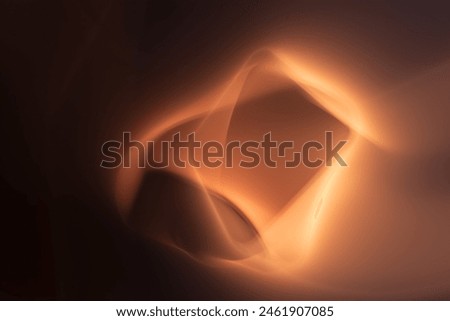 This image portrays an abstract pattern with warm tones of orange and brown, giving the impression of glowing shapes dancing in the darkness. The fluid forms create a sense of warmth and mystery.
