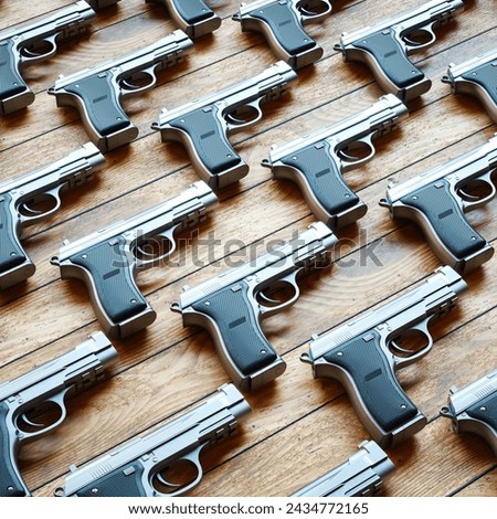 This photo captures an array of sleek silver semi-automatic handguns meticulously lined up on a wooden table, showcasing a striking contrast between the cold metal and the warm wood textures.