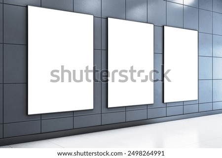 Three blank posters on a modern dark wall in a bright corridor with a sleek tiled design. Concept for exhibition, advertising, or promotion. 3D Rendering