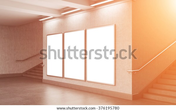 Three blank vertical billboard in the\
underground crossing, stairs up on both sides, blue sky seen from\
the street. Grey walls. Front view. Filter. Concept of underground\
advertising. 3D\
rendering