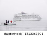 Three crewmen, standing in a passenger launch, return to a small cruise ship anchored in fog off the coast of Maine, USA, with digital oil-painting effect, for travel and maritime themes