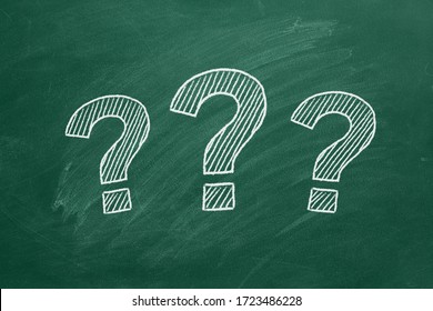 Three question marks drawn in chalk on a greenboard