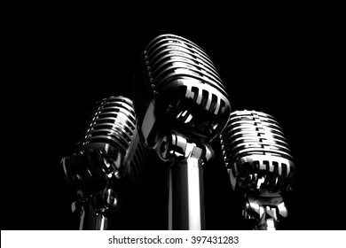 Three Silver retro microphones symbolizing trio, backing vocalist or a trio of singers. 3D illustration