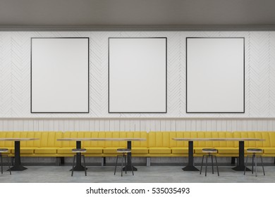 Three Vertical Framed Posters On A Cafe Wall With Yellow Sofas And Small Wooden Tables. 3d Rendering. Mock Up.